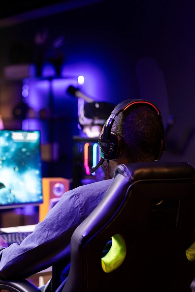 Fejhallgatót viselő gamer egy gamer székben ülve videójátékkal játszik
